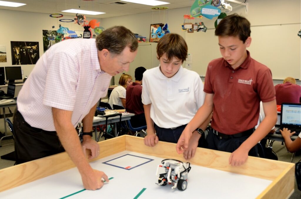 Dr. Spencer and two students test a robot on its course.