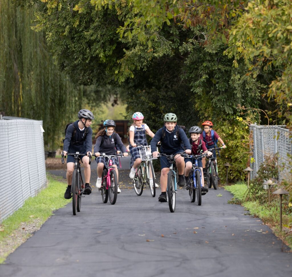 A group of students bike to school on the school's bike path.
