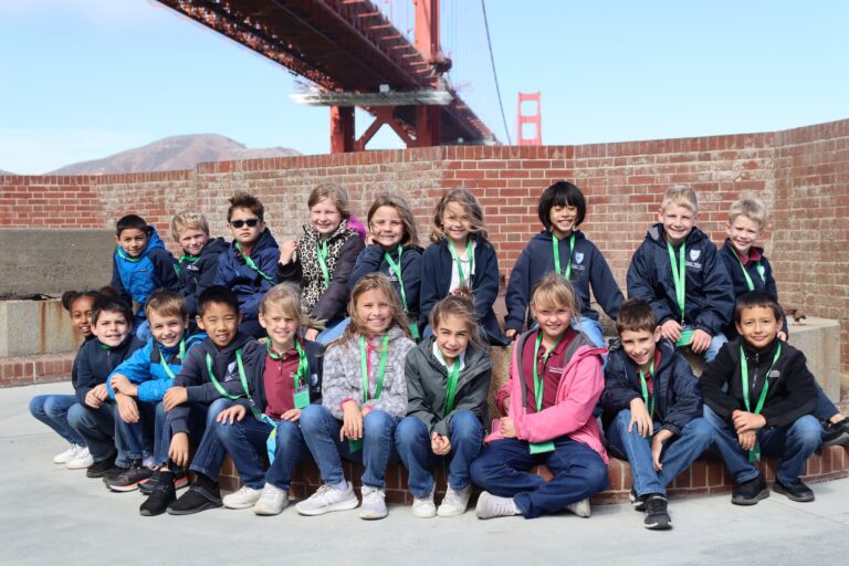 The fourth grade class sits in front of the Golden Gate Bridge in San Francisco
