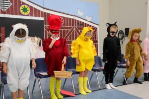 First graders perform a reader's theatre of The Little Red Hen.